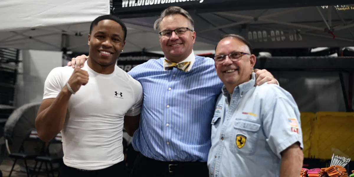 Boxer Floyd 'Kid Austin' Schofield with his arm around Mark Braswell at the Braswell Law tent